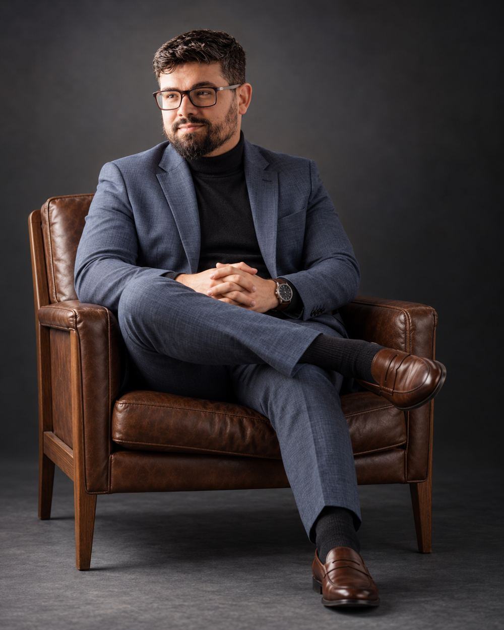 Dr. Guilherme Rocha de blazer azul, sentado em poltrona de couro